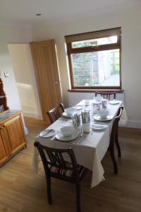 a dining room table with a white table cloth on it at Rose Vean Bed & Breakfast in Helston