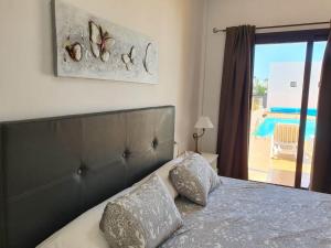 a bedroom with a bed with a view of a pool at Villa Santana in Playa Blanca