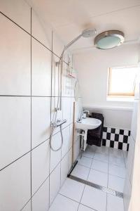 a white bathroom with a sink and a shower at VakantieStudio 88 in Kamperland