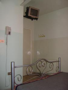 a bed in a room with a tv on the wall at Farah Hotel in Amman