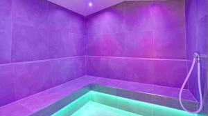 a purple bathroom with a tub with a purple wall at Country Hotel Timmendorfer Strand in Timmendorfer Strand
