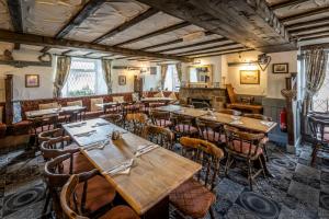 a restaurant with wooden tables and chairs in a room at The Cross Keys in Esh