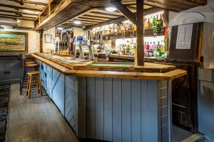 un bar con ripiano in legno in una stanza di The Cross Keys a Esh