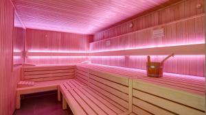 a pink sauna with benches and a bucket in it at Country Hotel Timmendorfer Strand in Timmendorfer Strand