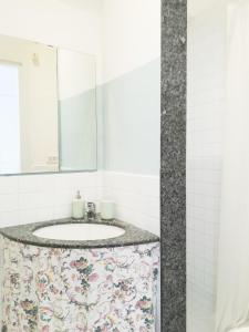 uma casa de banho com um lavatório e uma cortina de chuveiro floral. em NOVA DOMUS em Bitonto
