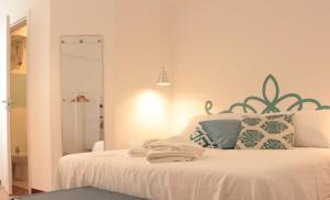 um quarto com uma cama com lençóis brancos e almofadas em NOVA DOMUS em Bitonto