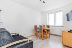 a living room with a table and chairs and a couch at Apartamenty Osiedle Bursztynowe by Renters in Kołobrzeg