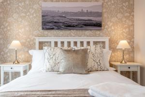 a bedroom with a white bed with two night stands at Abbey Villa Central Boutique House with Parking in St Andrews