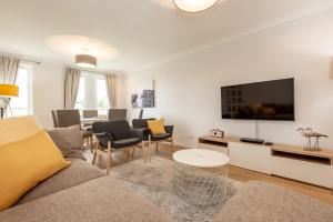 a living room with a couch and a tv at Abbey Villa Central Boutique House with Parking in St Andrews