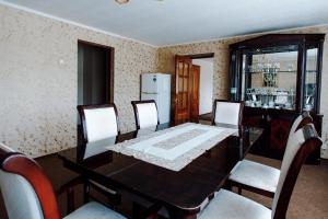 ein Esszimmer mit einem Tisch und Stühlen sowie einem Kühlschrank in der Unterkunft Spasskaya Hotel in Wologda