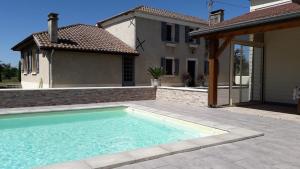 a swimming pool in front of a house at Gîte Yanou in Sault-de-Navailles