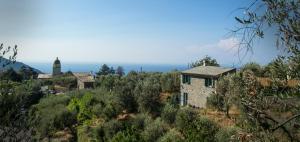 une maison en pierre sur une colline avec une tour en arrière-plan dans l'établissement The Garden, à Volastra