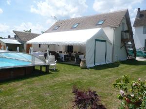 ein weißes Zelt in einem Garten neben einem Pool in der Unterkunft Villa Stuart in Aubigny-sur-Nère