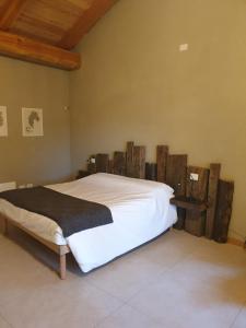 ein Schlafzimmer mit einem großen Bett mit Holzakzenten in der Unterkunft L'uovo e la faina in Busca