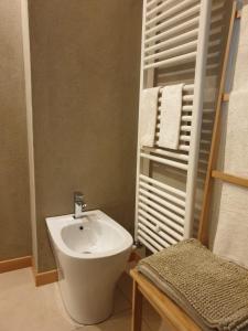 ein Bad mit einem Waschbecken, einem WC und Handtüchern in der Unterkunft L'uovo e la faina in Busca