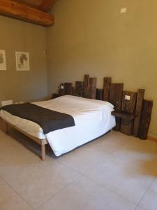 a bedroom with a white bed with wooden posts at L'uovo e la faina in Busca