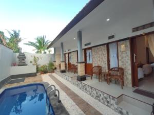 a house with a swimming pool and a living room at Gedhong Hostel in Nusa Penida