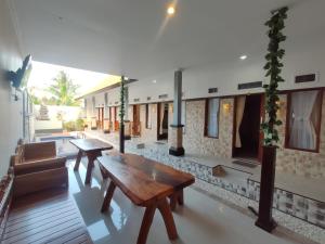 um quarto com uma mesa de madeira e um banco em Gedhong Hostel em Nusa Penida