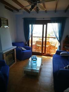salon z niebieskimi kanapami i stołem w obiekcie Las Alas del Mar. w mieście La Manga del Mar Menor
