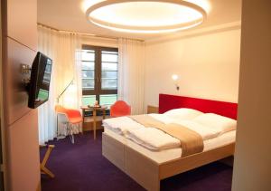 um quarto com uma cama, uma secretária e uma televisão em TraumHaus im Elsterpark em Herzberg