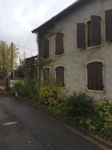 een oud huis met dichtgetimmerde ramen in een straat bij Gîte 65m2, 3 chambres, proxi commerces, à Mondelange in Mondelange