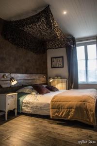 a bedroom with a large bed with a wooden headboard at Chambres d'hôtes Le Pessac in Vielmur