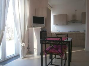 a kitchen with a table with a chair and a television at Residenza Don Agostino in Vallo della Lucania