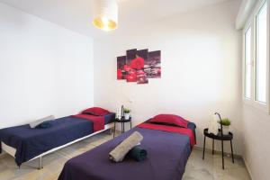 twee bedden in een kamer met witte muren bij Spacious Beachfront Flat with Sea Views and Private Indoor Parking in Benalmádena +36 foto's