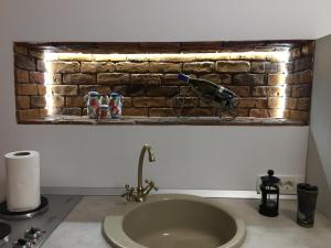 Un baño con lavabo y pared de ladrillo. en BrasovApart Piata Sfatului 2, en Brasov