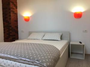 Un dormitorio con una cama con dos luces en la pared. en BrasovApart Piata Sfatului 2, en Brasov