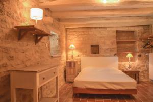 ein Schlafzimmer mit einem Bett in einem Steinzimmer in der Unterkunft Maison de Blanche in Chaudenay-le-Château