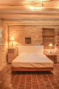 ein Schlafzimmer mit einem Bett in einer Steinmauer in der Unterkunft Maison de Blanche in Chaudenay-le-Château
