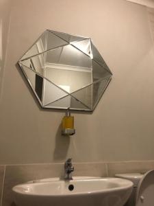 a mirror hanging above a sink in a bathroom at The Square 11 Private Suite in Port Elizabeth