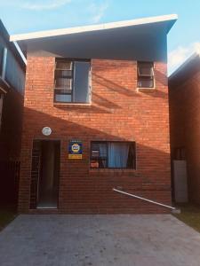 a red brick building with a door and a window at The Square 11 Private Suite in Port Elizabeth