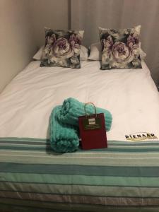 a bed with a blanket and a bag on it at The Square 11 Private Suite in Port Elizabeth