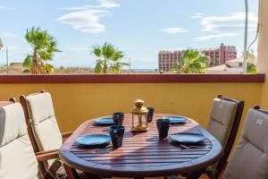 een houten tafel met blauwe gerechten en een lantaarn op een balkon bij Spacious Beachfront Flat with Sea Views and Private Indoor Parking in Benalmádena