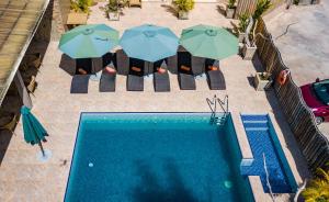an overhead view of a swimming pool with umbrellas and chairs at Chez Bea Luxury Villa in Baie Sainte Anne