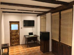 a room with a television and a table with a desk at Old Court in Curtea de Argeş