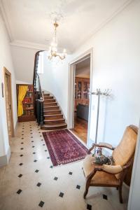 a hallway with a staircase with a chair and a rug at Maison des 7 lieux in Chablis