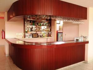 eine Bar in einem Restaurant mit einer roten Wand in der Unterkunft Hotel Siesta del Sur in Mexiko-Stadt