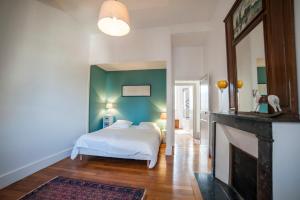 sypialnia z łóżkiem i kominkiem w obiekcie Maison des 7 lieux w mieście Chablis