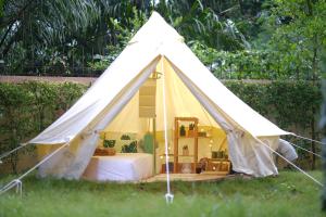 une tente blanche avec un lit dans l'herbe dans l'établissement O Little Tent de Koh Chang, à Ranong