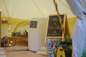 uma tenda com uma placa de quadro em cima de um frigorífico em O Little Tent de Koh Chang em Ranong