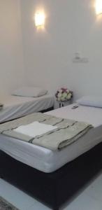 two twin beds in a room with at Seri Kenangan in Kota Samarahan +29 photos