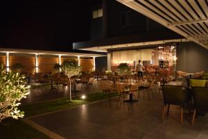 a restaurant with tables and chairs at night at BluePoint Hotel in Tepelenë