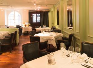 une salle à manger avec tables et chaises et nappes blanches dans l'établissement Hotel Taverne zum Kreuz, à Olten