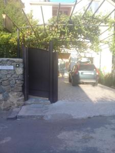 a car parked in front of a garage with a gate at Elmira in Borjomi