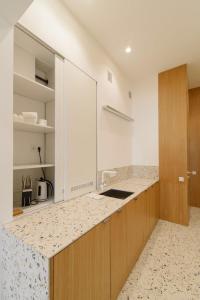 - une cuisine avec des murs blancs et un comptoir dans l'établissement SUNRISE apartment, à Lviv