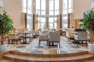 a restaurant with tables and chairs and large windows at Hotel Minin on Pozharskogo Street in Nizhny Novgorod