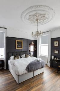 a bedroom with a large bed and a chandelier at The Warren Belfast in Belfast